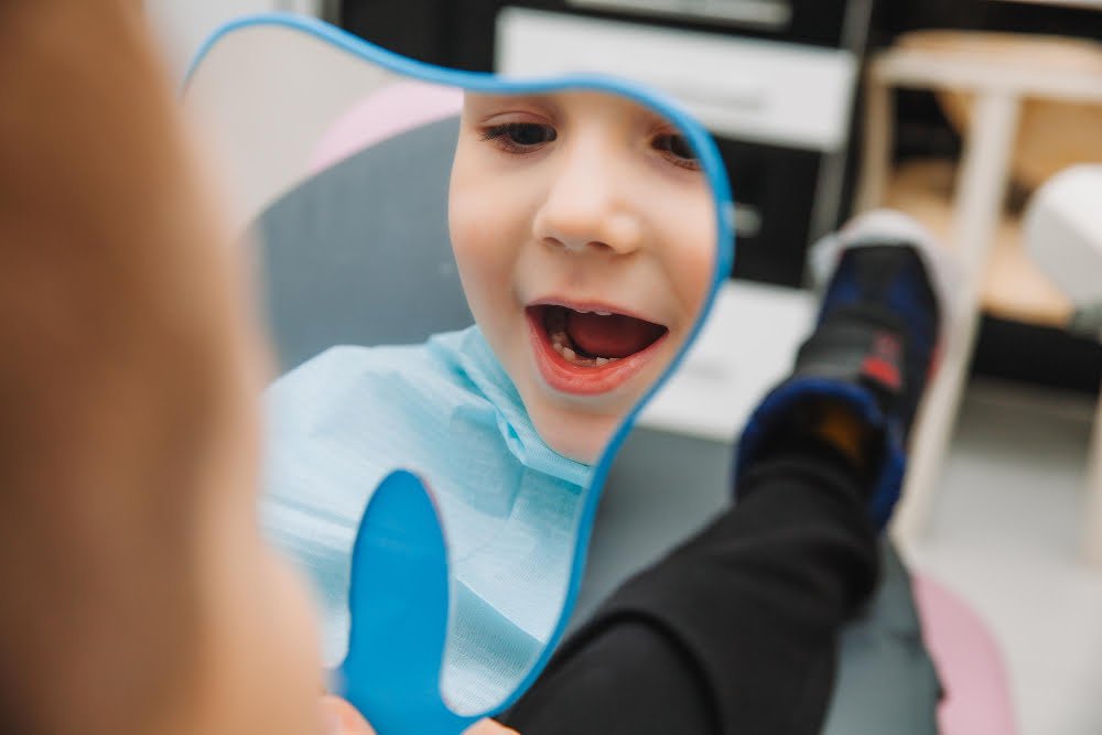 A Parent’s Guide to Pediatric Dentistry: Caring for Your Child’s Smile A young child sitting in a dental chair, smiling during a routine pediatric dental check-up.